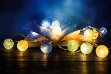 Book. Opened magic book with magic light. Abstract magic book on wooden background.