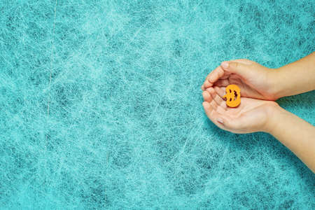 Holiday helloween on a cobweb background with a pumpkin in the hands of a childの写真素材