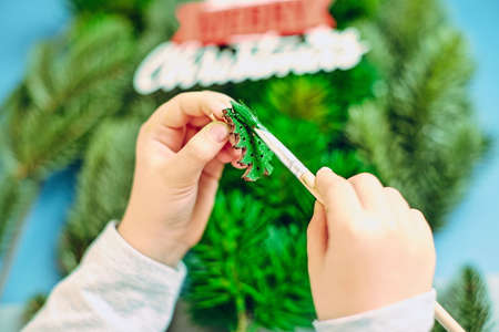 A girl draws a Christmas tree, preparing for the New Year 2022. Merry Christmas and happy new year conceptの写真素材