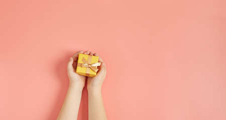 The child is holding a New Year's gift on a pink background with New Year's decorations.の写真素材