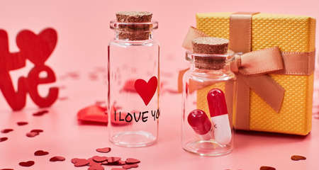 Love medicine. I love you .Tablets in jars are kissing Valentine's Day. Love background. Gifts in the form of hearts on a pink background with the inscription love.の写真素材