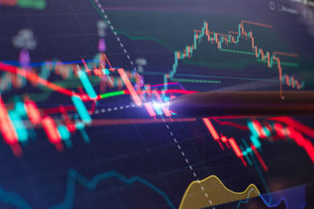 Financial chart with pen, stock analysis data for business background on digital screen. Graphs of...