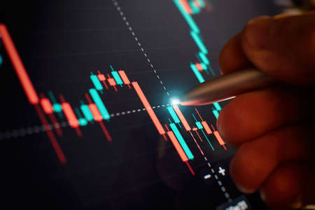 Financial chart with pen, stock analysis data for business background on digital screen. Graphs of...