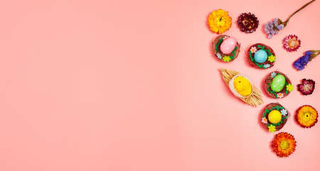 Coloeful easter eggs in nest on pink color background with space. minimal concept. Card with copy space for text.の写真素材