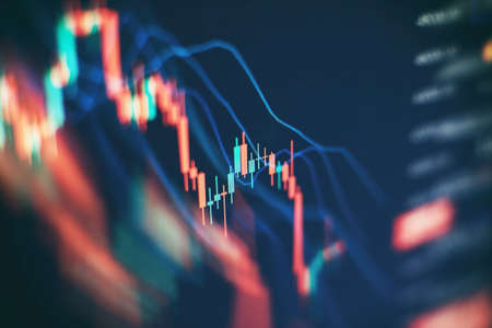 Concept of stock market and fintech. Blurry digital charts over dark blue background.の写真素材