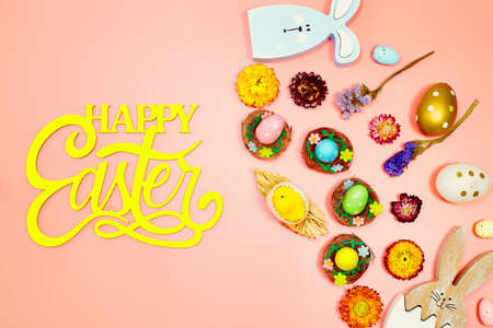 Coloeful easter eggs in nest on pink color background with space. minimal concept. Card with copy space for text.の写真素材