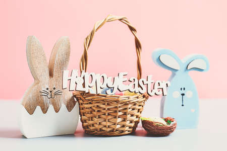 Easter colored eggs in a basket pink background. minimal concept. Card with copy space for text....