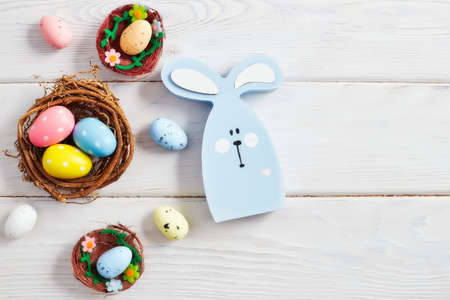 Coloeful easter eggs in nest on pink color background with space. minimal concept. Card with copy...