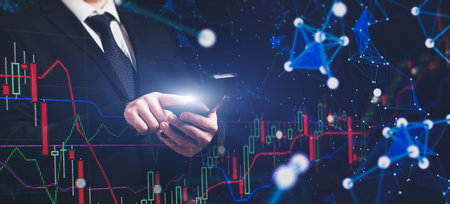 Man using smartphone with graphs analysis candle line and foreign currency rate on bokeh colors...