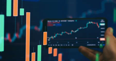 Trader investor broker holding finger using cell phone app executing financial stock trade market...