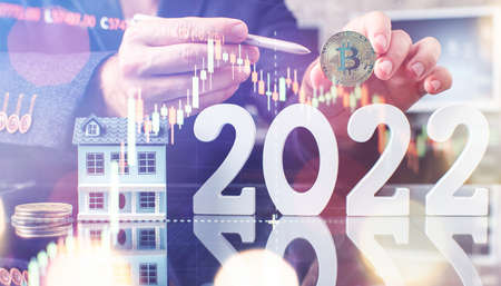 The man is holding a bitcoin coin 2022. Businessman puts in bitcoin. The concept of buying bitcoins. preservation. Cryptocurrency. close-up. virtual moneyの写真素材