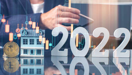 Male hands hold a wooden house, number 2023 on the table. tax payments, investment and banking...