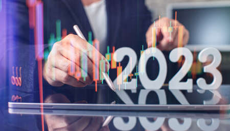 Hand write on tablet and touch screen. Stock market 2023 concept. businessman trader looking at chart analysis candleの写真素材