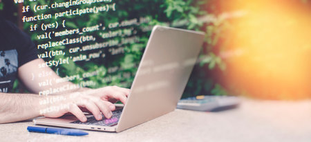 Man working on laptop in garden. Closeup of male hands typing on computer