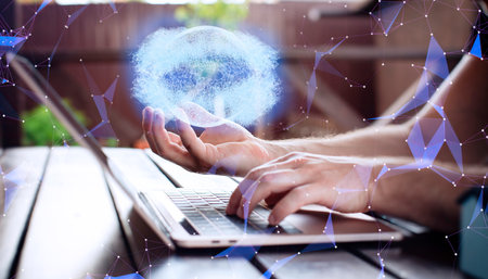 Man using laptop with digital sphere hologram on blurry background. Technology