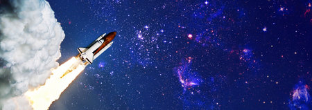Shuttle launch in the clouds to outer space. Dark space with stars on background.Spaceship flight.の写真素材