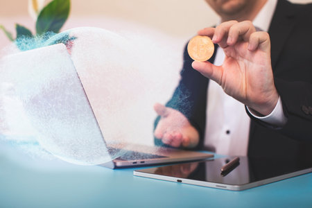 Laptop with chart and bitcoin in hands. Cryptocurrency gold coin, stock exchange graphの写真素材