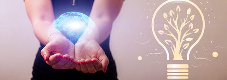 Woman holding a glowing earth globe on her hand a symbol of how to save natureの写真素材