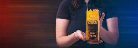 Girl holding gold bar, Business graph background. Buying goldの写真素材