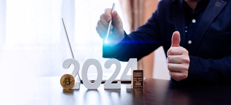 businessman buys gold and bitcoin in 2024 using digital technology and laptop computer.の写真素材