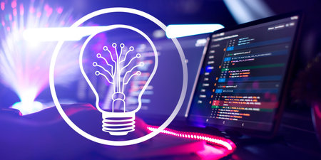 Creative glowing light bulb with computer program code on the screen. Technology and innovation...