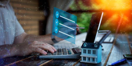 Businessman analyzing investment charts with calculator and laptop. Double exposure.の写真素材