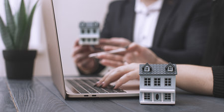 meeting using laptop and house model: concept of real estate investment and modern technologies in workの写真素材