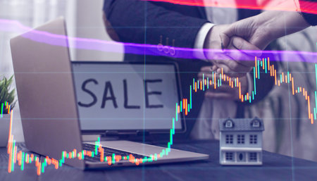 Handshake Agreement in Real Estate Sale with Laptop and Model Houseの写真素材