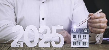Real estate investment and financial growth 2025 concept: hand with pen touching house model, moneyの写真素材