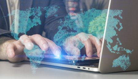 Global Digital Connectivity: Hands Typing on Laptop with Futuristic World Map