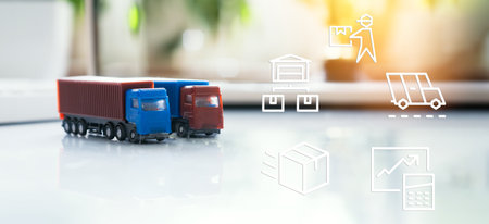 Toy cargo trucks on desk with logistics icons overlayed, representing shipping, freight management, and transportation planning in supply chain.の写真素材