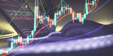 Hands analyzing candlestick chart on tabletの写真素材