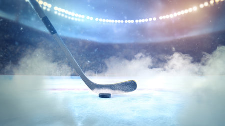 ice hockey stick striking a puck on the rink, with snow and ice particles flying under stadium lights.の素材
