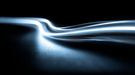 background with smooth glowing blue light trails flowing across a dark surface, creating a dynamic futuristic effect.の素材
