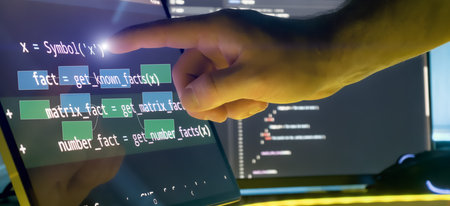 Programmer Hand Interacting with Code and Flow Diagram Overlay on Touchscreen in Futuristic Software