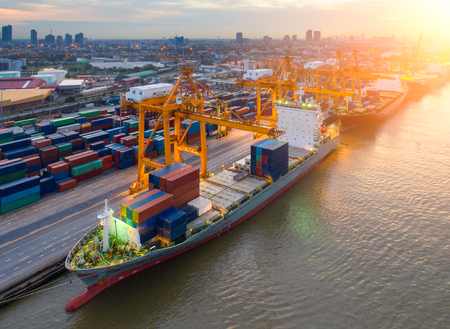 Containers yard in port congestion with ship vessels are loading and discharging operations of the transportation in international port.Shot from drone.の写真素材