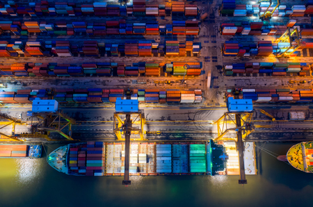 Containers yard in port congestion with ship vessels are loading and discharging operations of the transportation in international port.Shot from drone.の写真素材