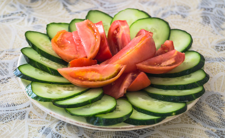 Sliced cucumbers and tomatoes on a plateの写真素材