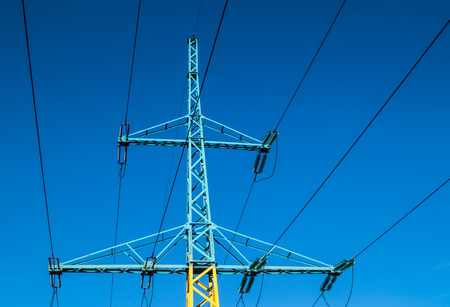 high voltage pole yellow blue against the blue skyの写真素材
