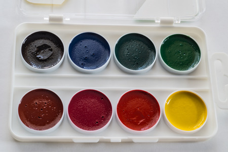 A set of paints of different colors in a white boxの写真素材