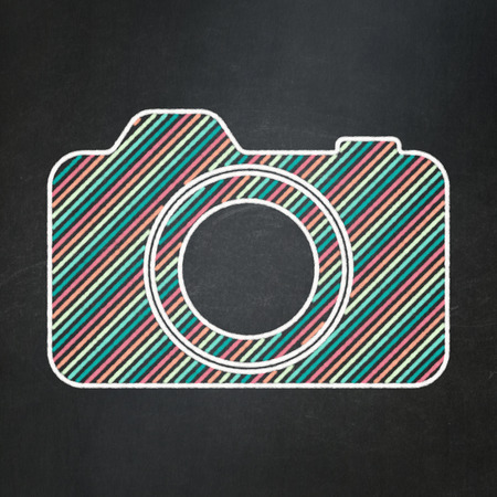 Tourism concept: Photo Camera icon on Black chalkboard background, 3d renderの写真素材