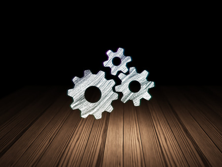 Information concept: Glowing Gears icon in grunge dark room with Wooden Floor, black background, 3d renderの写真素材