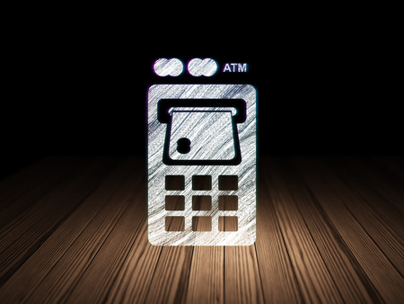 Money concept: Glowing ATM Machine icon in grunge dark room with Wooden Floor, black background, 3d renderの写真素材