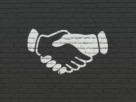 Political concept: Painted white Handshake icon on Black Brick wall backgroundの写真素材