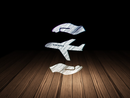 Insurance concept: Glowing Airplane And Palm icon in grunge dark room with Wooden Floor, black backgroundの写真素材