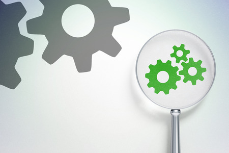 Web development concept: magnifying optical glass with Gears icon on digital background, empty copyspace for card, text, advertisingの写真素材