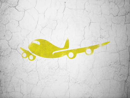 Vacation concept: Yellow Airplane on textured concrete wall backgroundの写真素材