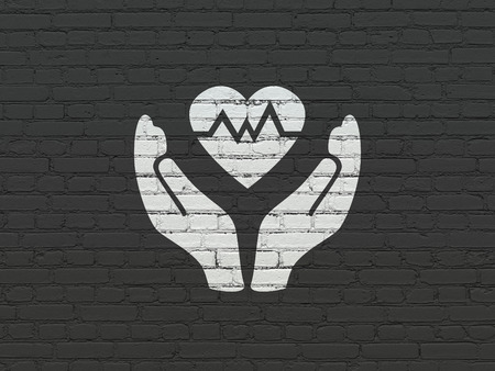 Insurance concept: Painted white Heart And Palm icon on Black Brick wall backgroundの写真素材
