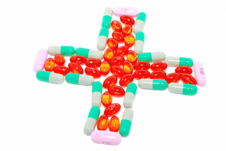 Very bright red, white, pink  and green & gray pills making the cross. の写真素材