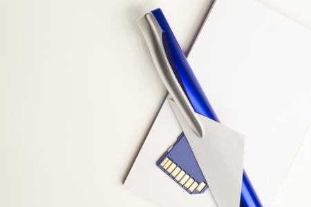Memory card and blue pen with the paper backgroundの写真素材